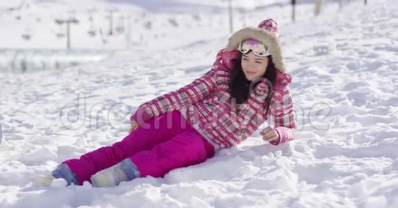 带滑雪护目镜的粉红色雪衣青年女子视频的预览图