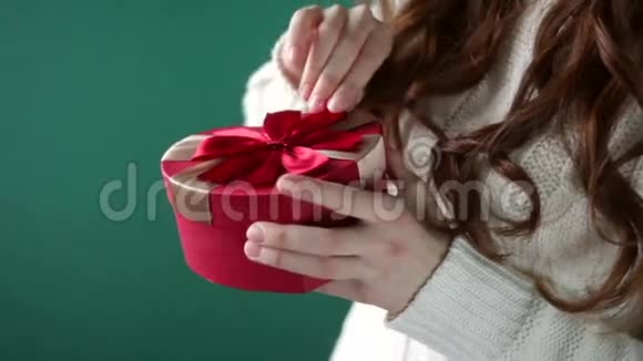 美丽的女孩拿着一个红色的蝴蝶结的礼物视频的预览图