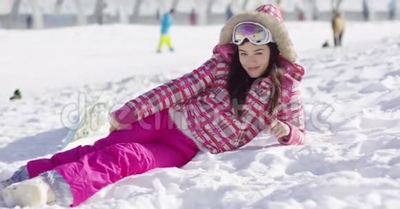 带滑雪护目镜的粉红色雪衣青年女子视频的预览图