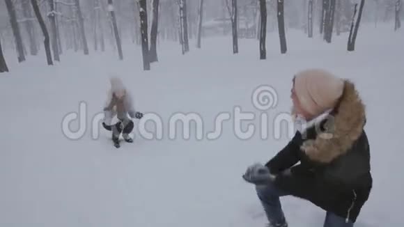 在白雪覆盖的森林里相爱的年轻夫妇视频的预览图