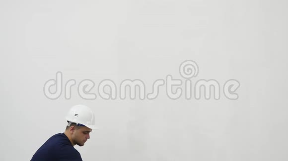 青年男子在装修房屋时粉刷墙壁视频的预览图