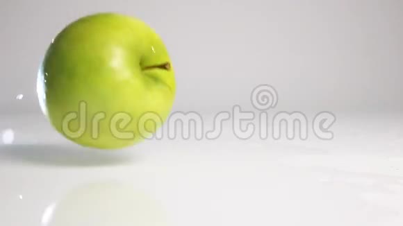 绿苹果落在白色的表面上视频的预览图