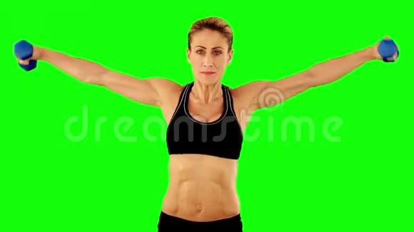 超级合身的女人在黑色运动胸罩和短裤中举起哑铃视频的预览图