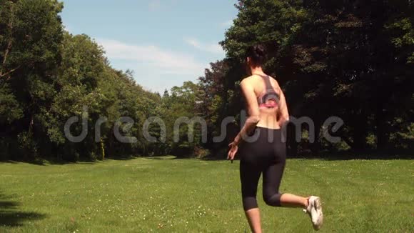 运动女人在草地上奔跑的后景视频的预览图