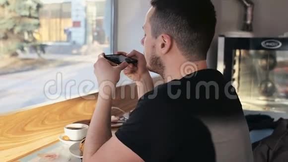 帅哥在咖啡馆里用手机聊天视频的预览图