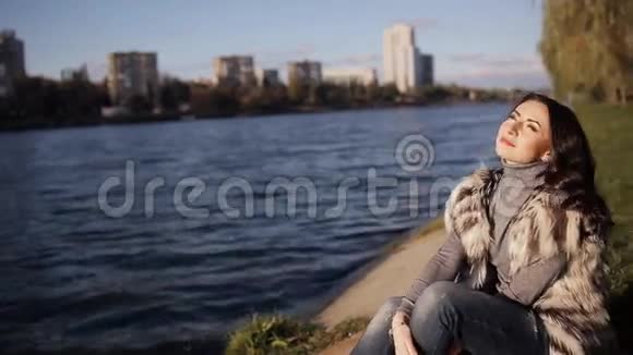 坐在河岸边的漂亮女人视频的预览图