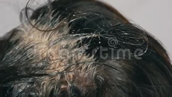 一个中年妇女的过度生长的灰色根她用特殊的刷子给自己的头发涂上颜色深色头发白色视频的预览图