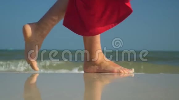 幸福的女人靠近海浪海洋冲浪热带岛屿那个穿红色衣服的女人在海滩上散步特写视频的预览图