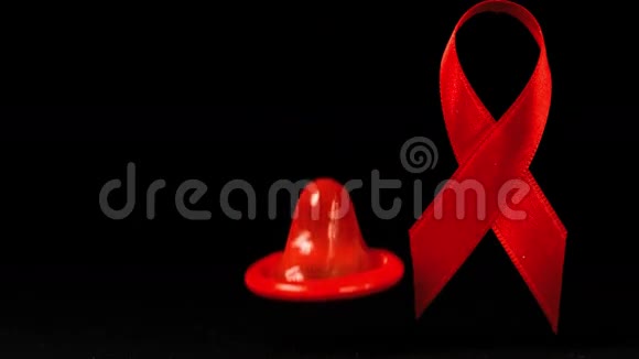 避孕套掉在黑色背景上的红色丝带前面视频的预览图