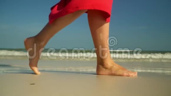 那个穿红色衣服的女人在海滩上散步夏装美少女特写海洋冲浪热带岛屿a视频的预览图