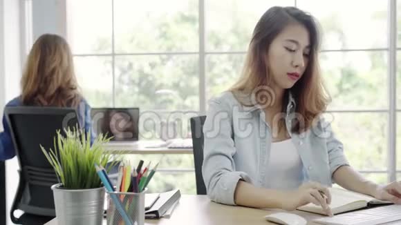 亚洲商界女性在电脑上工作而在办公室坐在办公桌上穿着智能休闲服装视频的预览图