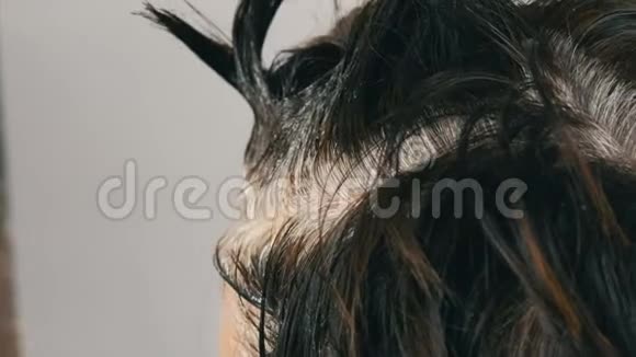 一个中年妇女的过度生长的灰色根她用特殊的刷子给自己的头发涂上颜色深色头发白色视频的预览图
