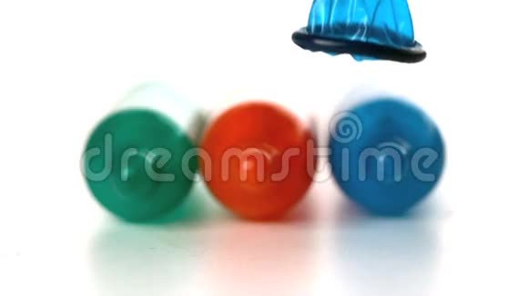 五颜六色的避孕套掉在被炸的避孕套前面视频的预览图