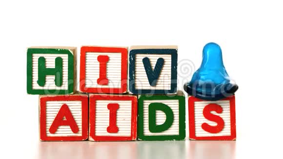 蓝色避孕套掉落在拼写艾滋病和艾滋病毒的积木上视频的预览图