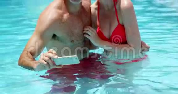 情侣在游泳池里用手机自拍视频的预览图