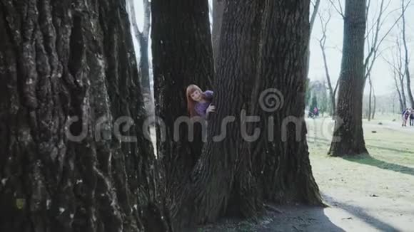 红发女孩正在阳光明媚的公园里玩耍视频的预览图