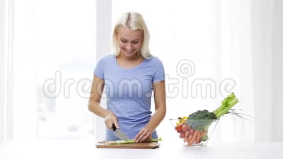 微笑的年轻女子在家切芹菜视频的预览图
