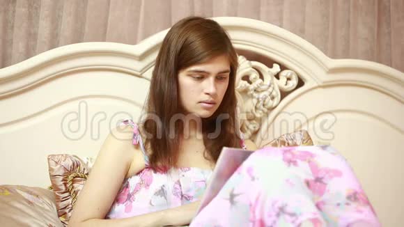 一个在床上用电脑工作的年轻女孩社会网络视频的预览图