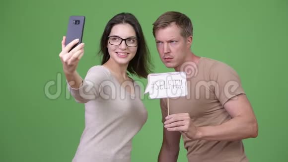 年轻的幸福夫妇在绿色背景下一起自拍视频的预览图