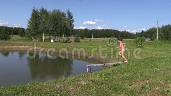 小女孩从木桥跳到池塘里的湖水视频的预览图