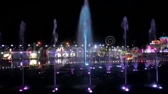 带有彩色背光的美丽的夜间喷泉视频的预览图