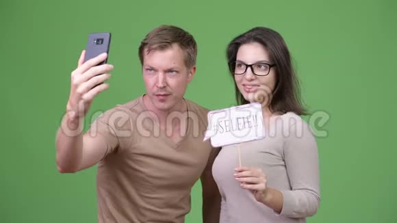 年轻的幸福夫妇在绿色背景下一起自拍视频的预览图