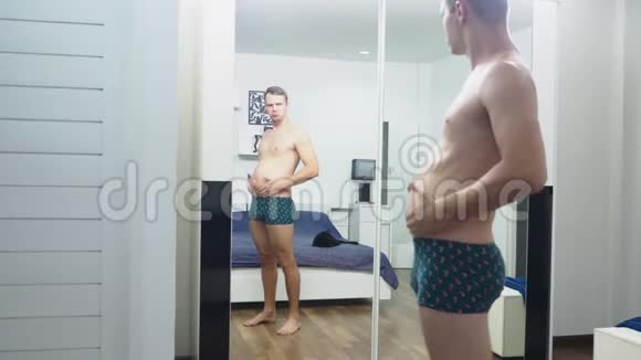 年轻人在卧室的镜子前检查自己的肌肉视频的预览图