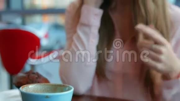 一个金发美女在喝咖啡打电话视频的预览图