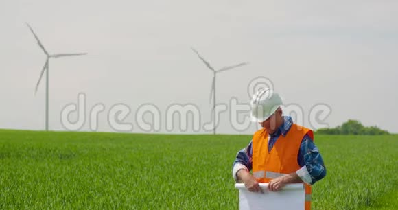 工程师在查看风车农场时分析计划生态能源概念视频的预览图
