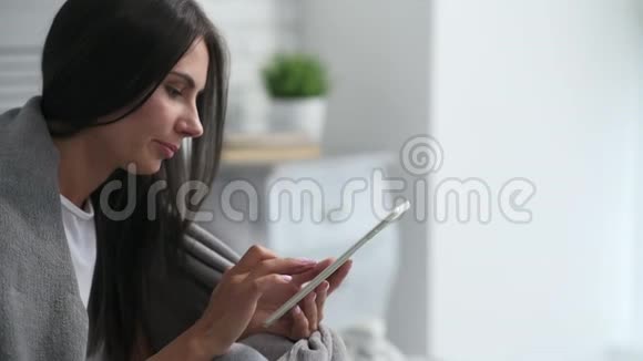 快乐的年轻女人用她的平板电脑视频的预览图