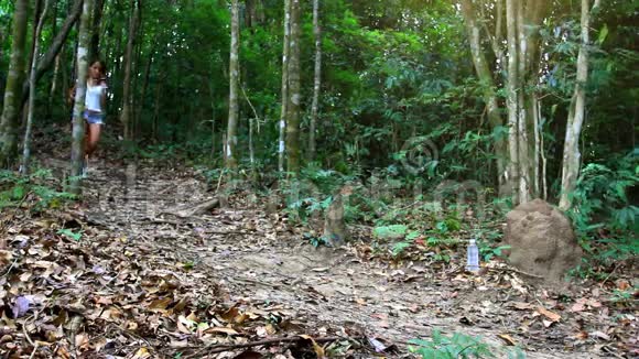 在丛林森林里奔跑喝酒的运动女人视频的预览图