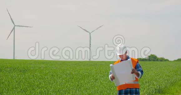 工程师在查看风车农场时分析计划生态能源概念视频的预览图