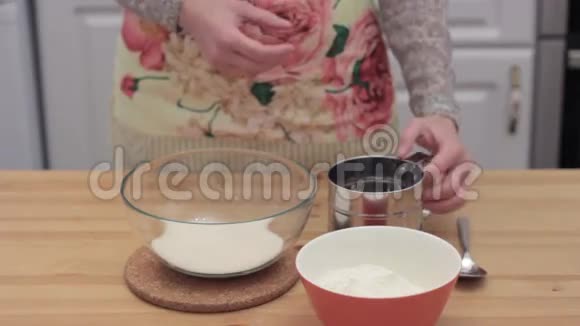 女人的手把面粉筛到碗里视频的预览图