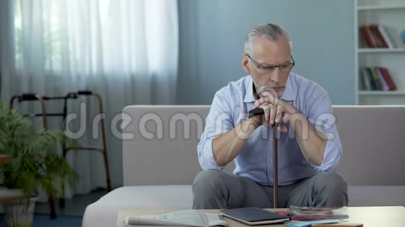 老人坐在养老院的沙发上思考着生活悲伤视频的预览图
