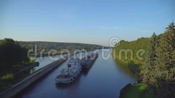 船只和驳船通过河闸沿运河移动视频的预览图