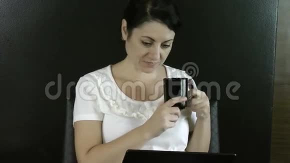 女商人用她的笔记本电脑和咖啡视频的预览图