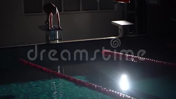 男游泳运动员从起点跳下来开始在游泳池里游泳职业运动员训练潜水和溅水视频的预览图