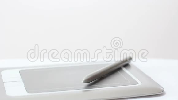 人在桌上的平板上画一支笔贴在桌子上视频的预览图