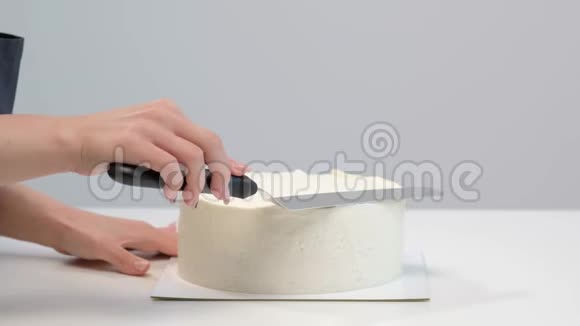 白色光滑的圆柱形蛋糕毛坯糖果师创造了一个糕点铲子的形状视频的预览图