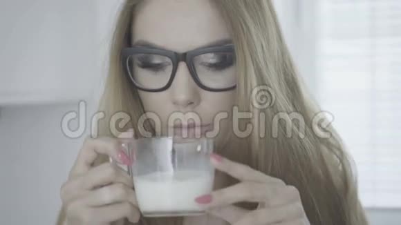 美丽的女人喝着一杯牛奶视频的预览图