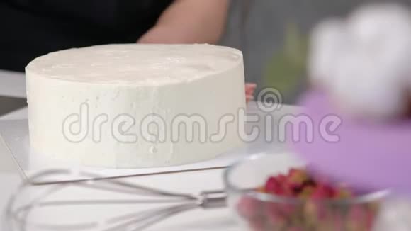 白色光滑的圆柱形蛋糕毛坯糖果师创造了一个糕点铲子的形状视频的预览图