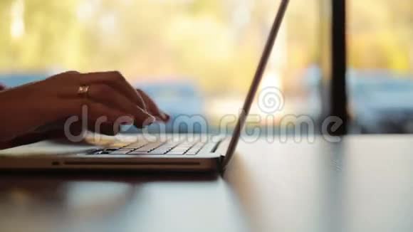 女人在笔记本电脑上打字电脑在窗边左滑滑梯视频的预览图