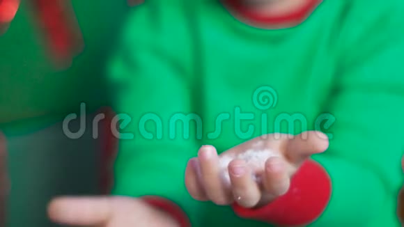 穿着绿色小矮人服装的孩子坐在装有鹿角的礼盒上视频的预览图