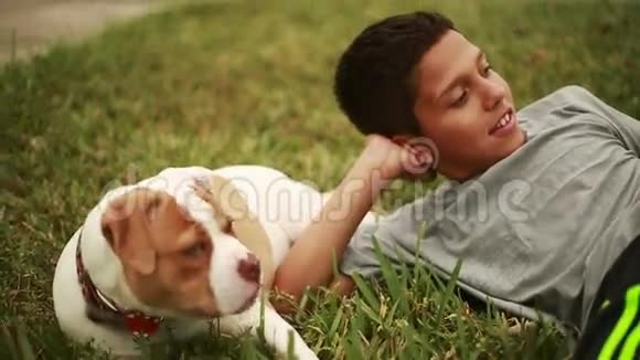 可爱的孩子和可爱的狗躺在草地上视频的预览图