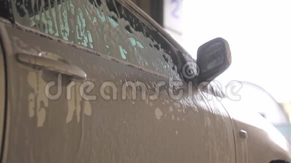 男人用洗发水洗银色的汽车刷子视频的预览图