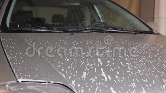 男人用洗发水洗银色的汽车刷子视频的预览图