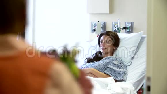 志愿者为床上女性患者提供一束鲜花视频的预览图