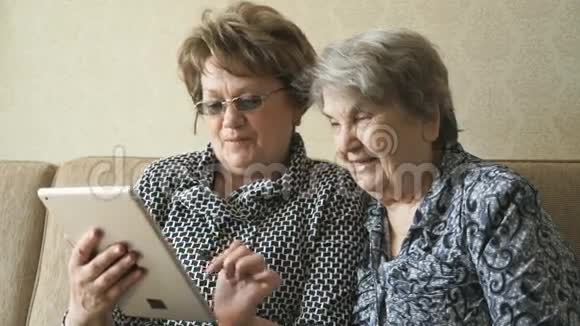 两个女人在数码平板电脑上看照片视频的预览图