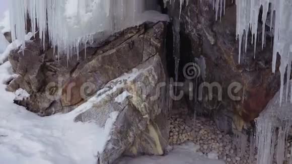 岩石中有冰柱的石窟和裂缝视频的预览图
