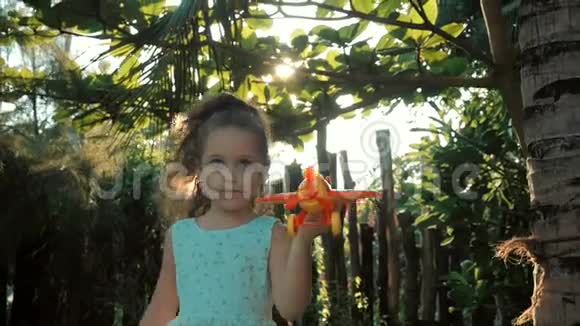 快乐的孩子在日落背景下带着玩具飞机跑步视频的预览图